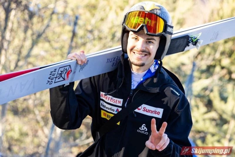 Sandro Hauswirth lächelnd mit den Ski auf der Schulter